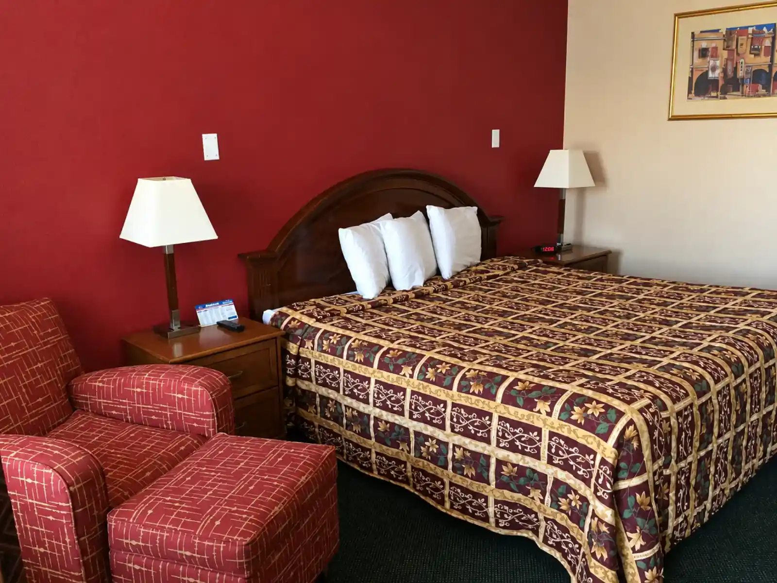 Bestway Inn king bed with bedside lamps and an armchair